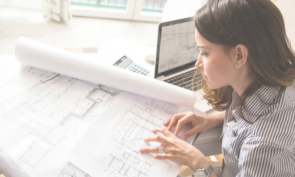 Woman looking at engineering papers.