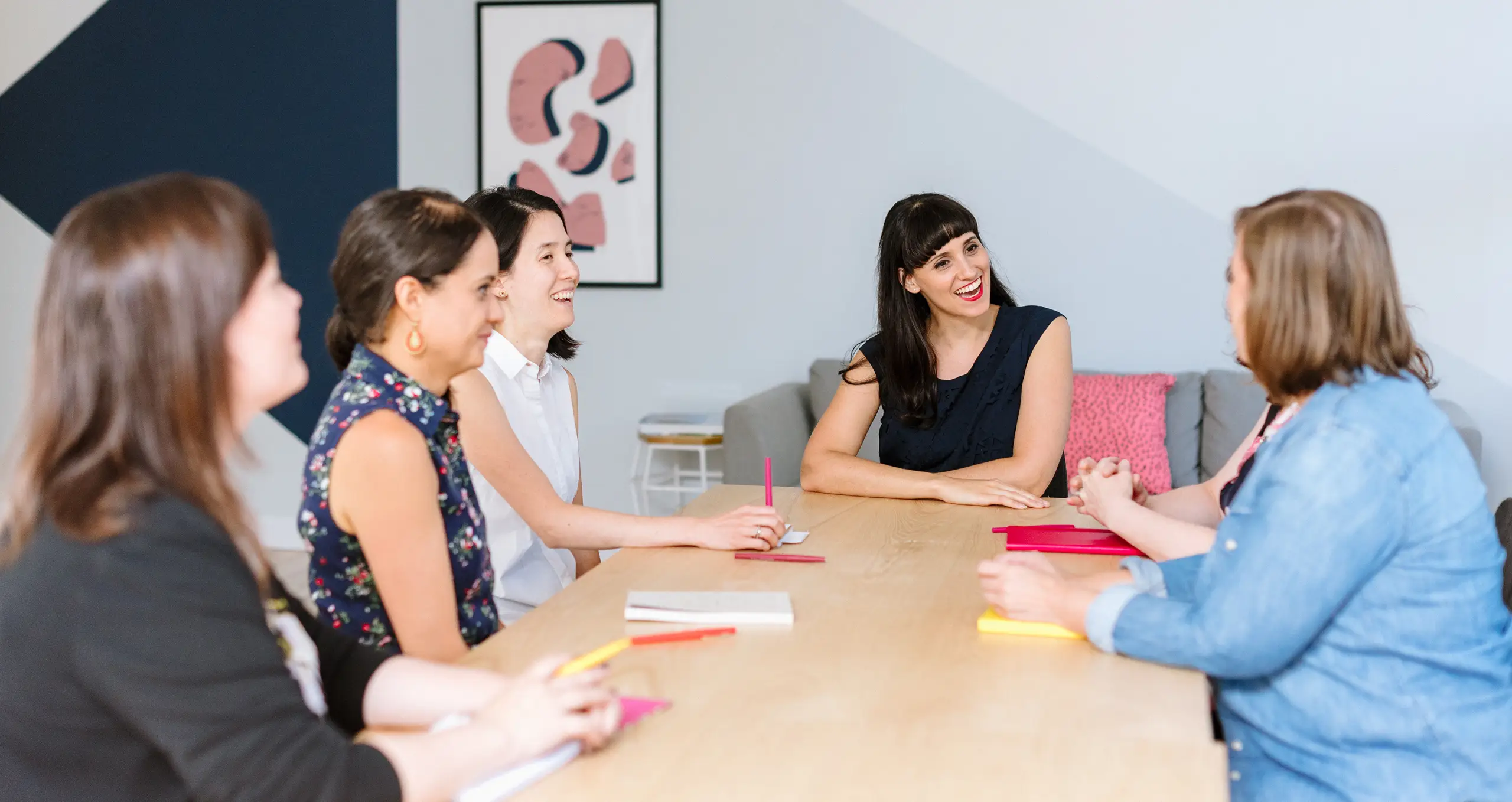 Maya Sharfi giving a workshop with women gathered around a table.